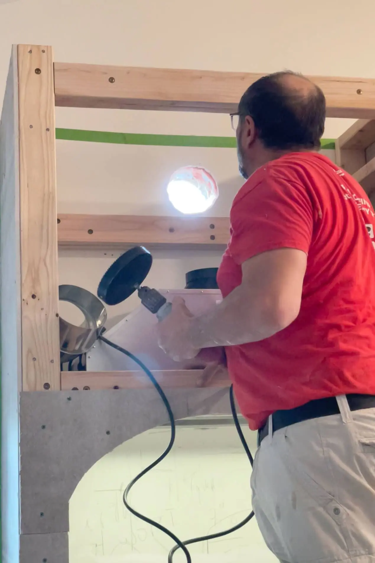 Cutting hole for vent on range hood.